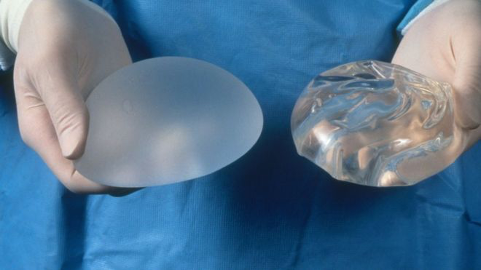 Surgeon holding breast implants