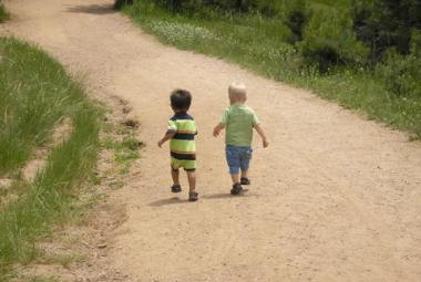 Toddlers walking on dirt road